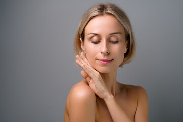 Natural beauty. Blonde woman with healthy skin.  No makeup. Grey background.