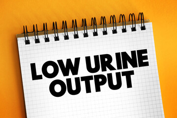 Low urine output text on notepad, medical concept background
