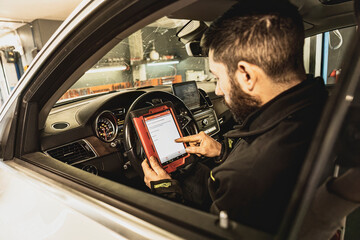Mechanic Running Diagnostics on Modern Car Computer