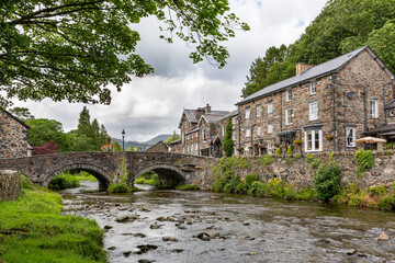 The bridge over the River Colwyn in the picturesque village of Beddgelert in the Snowdonia National Park, North Wales. - obrazy, fototapety, plakaty
