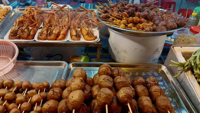 Traditional authentic khmer street food or hang bai displayed in stalls at the riverside night market in Kampot, Cambodia