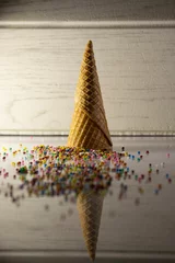 Tuinposter Vertical shot of a waffle cone with scattered candies © Juan Carlos Rodriguez Garcia/Wirestock Creators