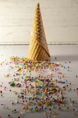 Gordijnen Vertical shot of a waffle cone with scattered candies © Juan Carlos Rodriguez Garcia/Wirestock Creators