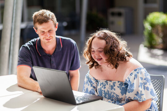 Happy young person with disability doing one on one activity with her NDIS provider