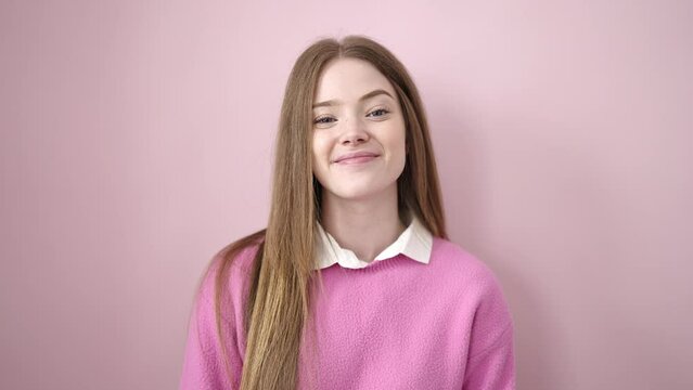 Young blonde woman smiling confident standing over isolated pink background