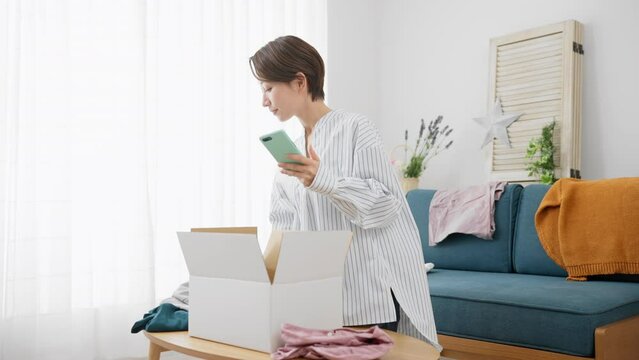 通信販売で衣類を売買する若い女性　ビジネスイメージ