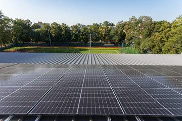 A set of solar panels mounted one next to the other on the roof of the building.