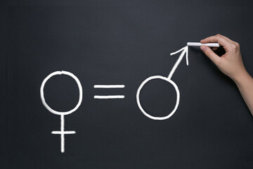 gender equality concept, drawing on a school blackboard with chalk, male and female icons and an...