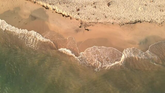 Aerial view of sea waves with foam on a Keramoti Beach in Greece