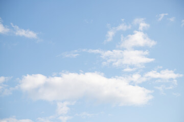 Blue sky with white fluffy clouds in sunny weather.