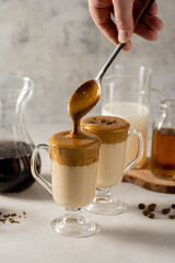 Dalgona coffee. Iced whipped coffee and milk. Refreshing coffee drink in glass cups.