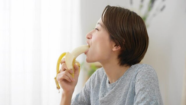 バナナを食べる若い女性　飲食イメージ	
