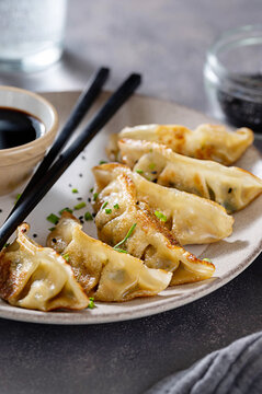 Fried dumplings gyoza with soy sauce, and chopsticks.