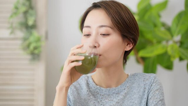 青汁を飲む若い女性　飲食イメージ	

