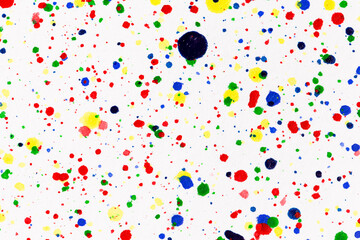 Paint splatters on bright material. Watercolor on white paper.