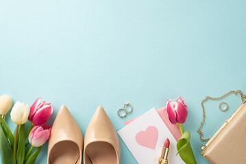 Trendy Mother's Day concept. Flat lay of high-heels, handbag, present box, tulips, lipstick, postcard on pastel blue background with a blank space for text or advert