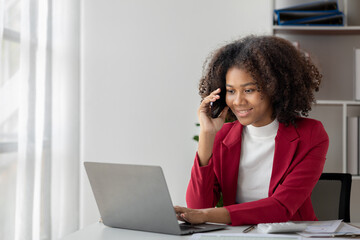 A young American woman is a start-up businesswoman, she sits in her office and talks on the phone with her partner, management and business from a new generation. Startup business management concept.