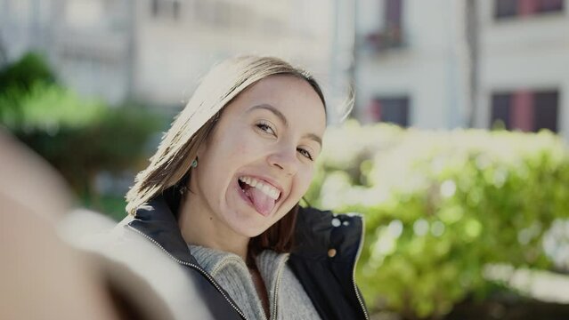 Young beautiful hispanic woman smiling confident making selfie by camera at park