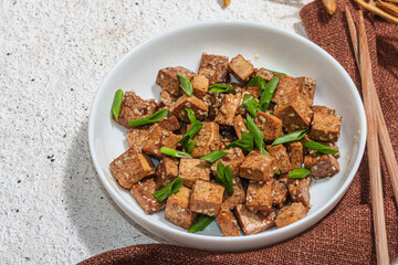 Fried teriyaki Tofu with scallions and sesame seeds. Healthy vegan meatless meal rich in protein