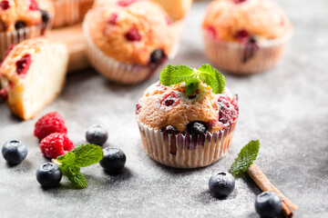 Freshly baked muffins with powdered sugar and fresh berries