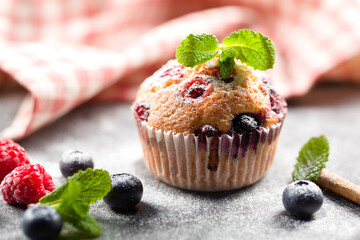 Freshly baked muffins with powdered sugar and fresh berries