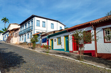 Sabará. Beautiful colorful old mansions in the historic city of Sabará. Brazil. Blue sky. Stone-paved street.