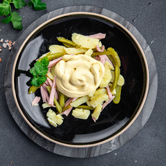 fresh potato salad, gherkin, sausage, mayonnaise ready to eat meal food snack on the table copy space food background rustic top view