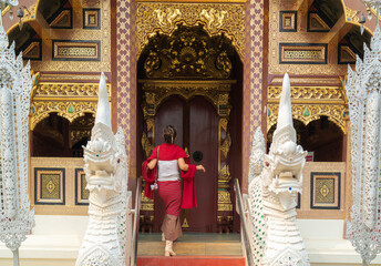Asian woman traveller intraditional red dress travel in old temple
