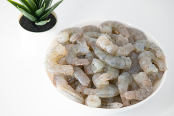 Fresh Raw shrimps cut and cleaned and kept it in a white bowl. Raw shrimps in white bowl and isolated in white background. Selective focused image...