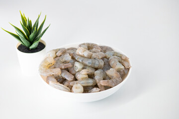 Fresh Raw shrimps cut and cleaned and kept it in a white bowl. Raw shrimps in white bowl and isolated in white background. Selective focused image...