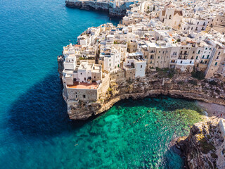People bathing in the sun in Blue Lagoon, Polignano a Mare the beach. Aerial view of swimming in...