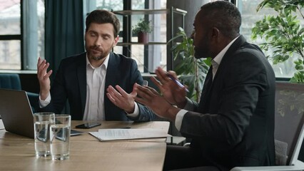 Two dissatisfied diverse businessmen arguing in office meeting business conflict Caucasian man manager with laptop presentation African American leader investor problem mistake work failure bad result