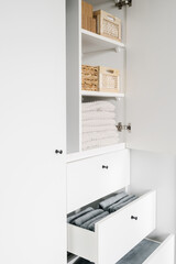 storage bamboo boxes with clean linen in white cabinet