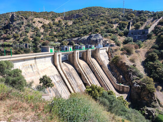 Photograph of a dam without water with booths and railings in greenish tones