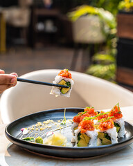 hand picking up sushi to eat