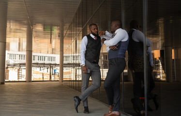 Portrait of two handsome african american businessman partner friends in suit against modern building exterior