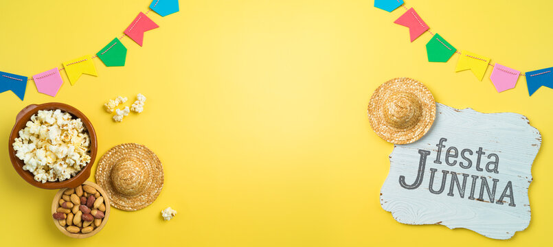 Festa Junina party background with popcorn, peanuts and wooden board. Brazilian summer harvest festival concept. Top view from above