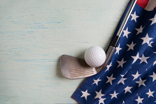 Golf ball with flag of USA on wood blue table background