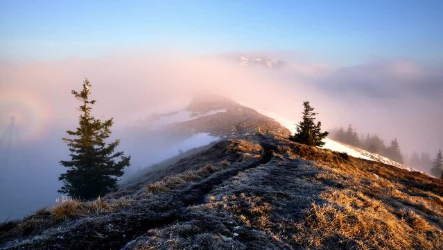 Clouds flowing over a mountain ridge and a mountain peak in a national park in Carpathian Mountains