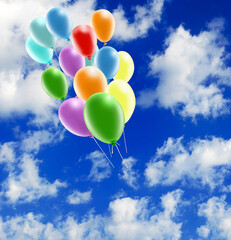  bright multi-colored inflatable balls against the background of the sky with clouds