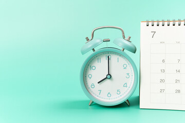close up of calendar and alarm clock on the green table background, planning for business meeting...