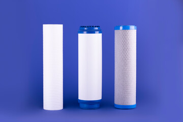 Cartridges for water treatment systems on violet background..