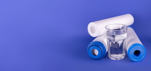Banner set cartridges for water filter with clear glass of water isolated on blue background....
