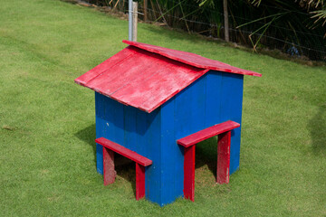 Photo of colorful wooden dog house on field