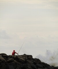 FISHING ALONE ON TOP OF ROCKS