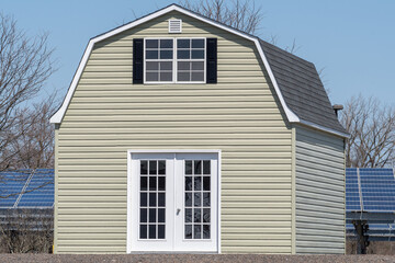 Fototapeta na wymiar new wooden storage shed with garage style door white sliding door