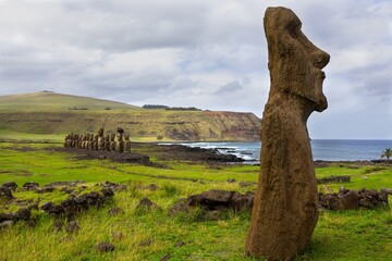 Moais Monument at Ahu Tongariki Archeological Site on Easter Island or Rapa Nui, Chile.  Standing Moai Portrait in Foreground with Famous Row of Fifteen Moai Statues in Background