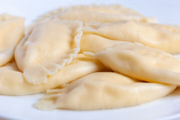 Fototapeta na wymiar Boiled dumplings with cheese inside on a white plate. Vareniki