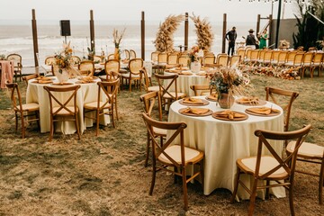 View of wooden chairs and tables on a wedding day at outdoor hall