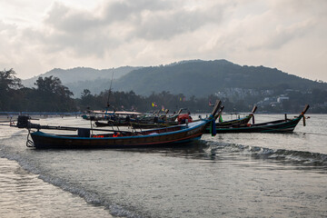 Beautiful boats stand near the beach. Early morning on the beach. National boats of Thailand. Beautiful sea.